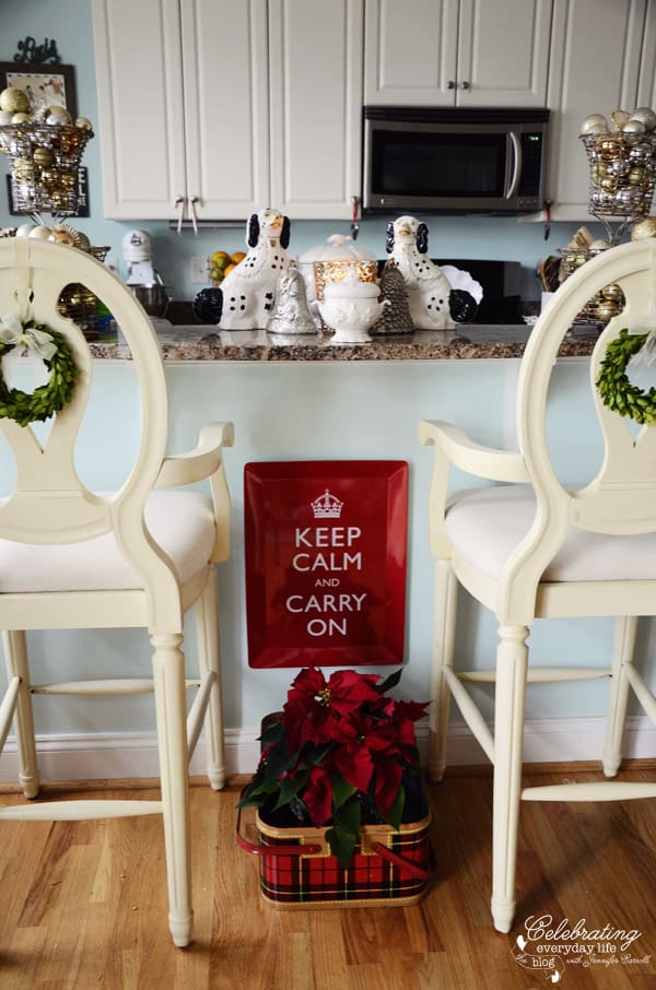 Celebrating Everyday Life Kitchen, Bar stools with boxwood wreaths, red keep calm and carry on tray, poinsettia in vintage plaid picnic basket